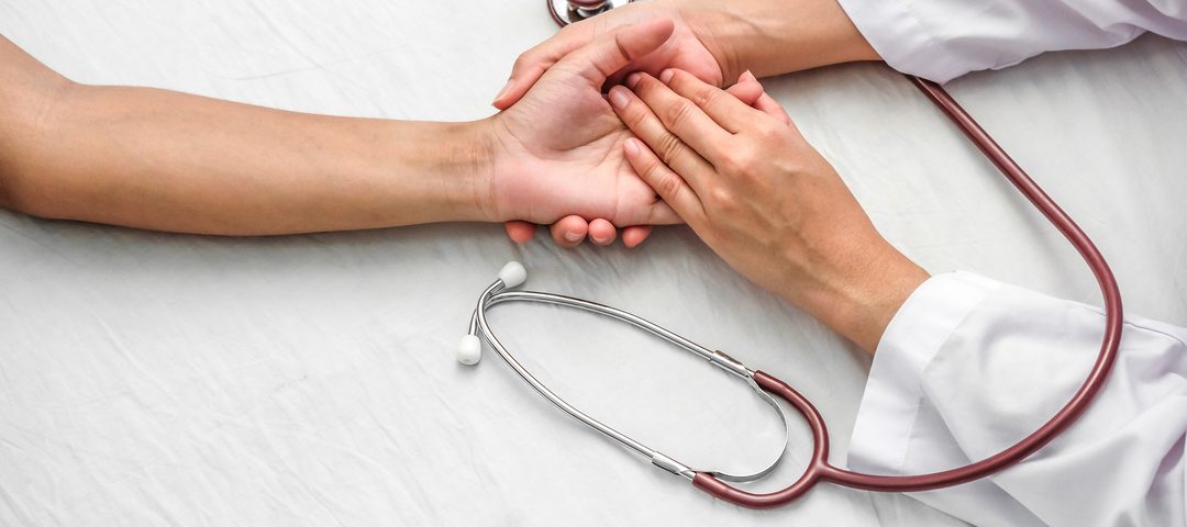 Mioma uterino: médico segura mão de paciente.