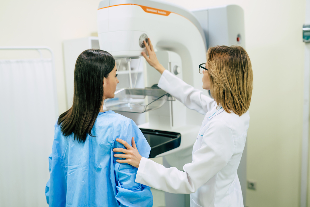 mamografia digital: mulher realizando mamografia digital com ajuda de doutora