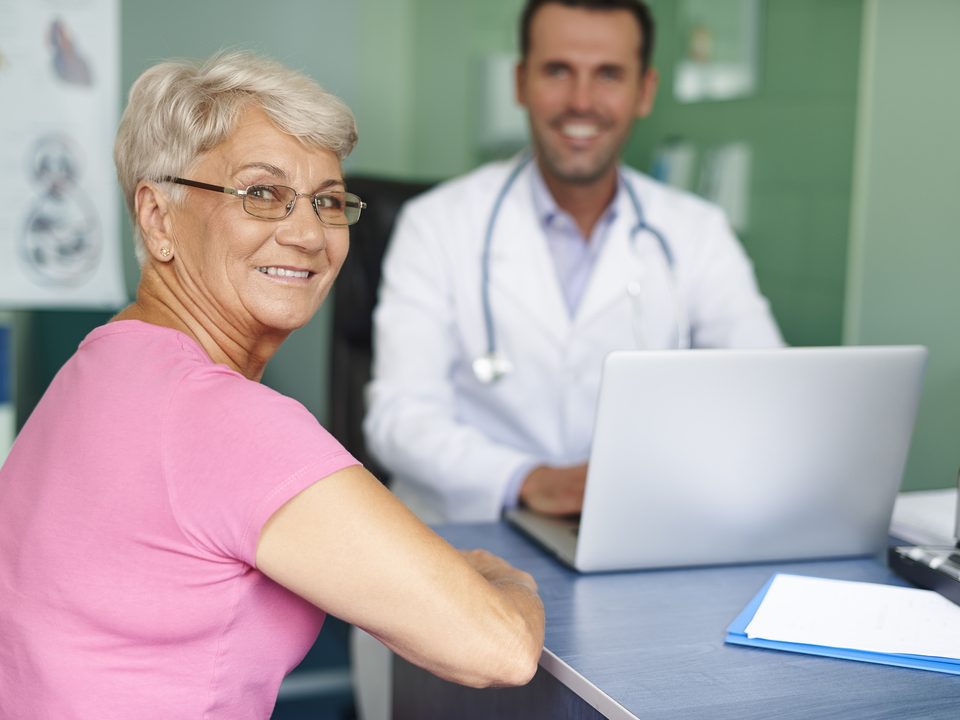 exames de rotina: senhora e doutor sorrindo em consulta