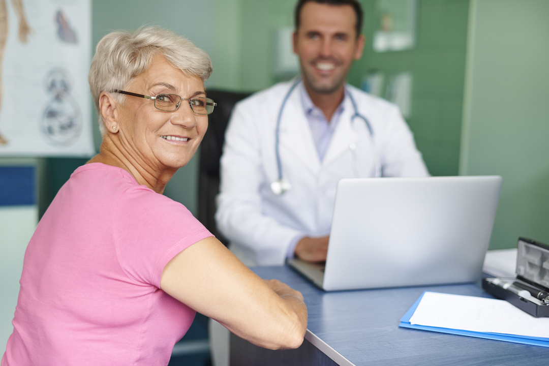 exames de rotina: senhora e doutor sorrindo em consulta